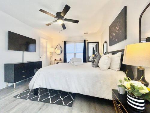 a bedroom with a white bed with a ceiling fan at 5BR Southern Dream Home in Columbia