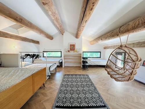 Cette grande chambre comprend deux lits et un lustre. dans l'établissement Des vacances au Pontpadour !, à Entraigues-sur-la-Sorgue