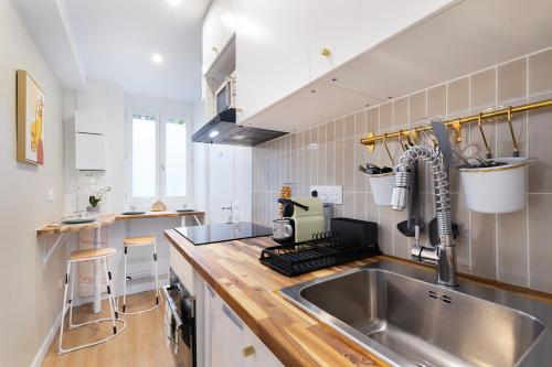 une cuisine avec un évier et un plan de travail dans l'établissement Appartement 2 pièces Boulogne Roland Garros, à Boulogne-Billancourt