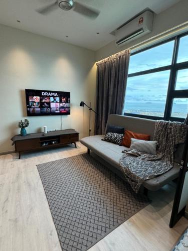 Una sala de estar con un sofá y un televisor de pantalla plana. en Jesselton Quay l Family Suite l Deluxe l Sunset Seaview l 2R1B l 5 pax, en Kota Kinabalu