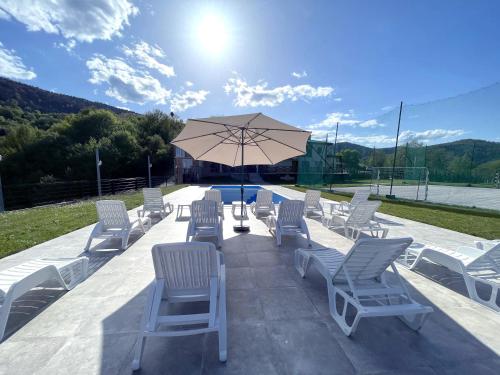 a group of chairs and an umbrella on a patio at Villa Sarajevo in Vareš