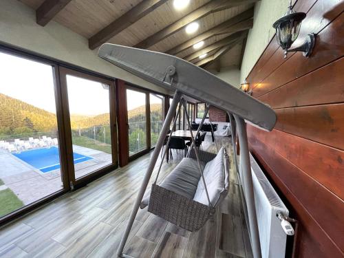 a swing in a room with a view of a pool at Villa Sarajevo in Vareš