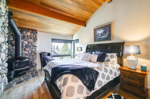 a bedroom with a bed and a stone fireplace at 1 Mi to Lake Tahoe Home with Hot Tub and Decks in Tahoe City