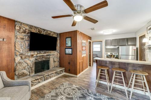 a living room with a fireplace and a flat screen tv at Rustic Angel Fire Condo Resort Shuttle On-Site! in Angel Fire