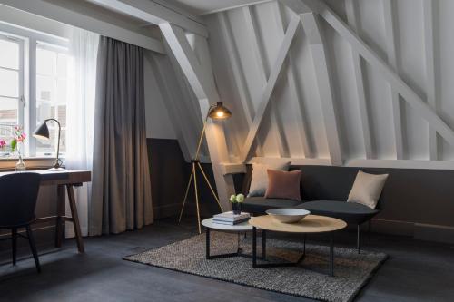 a living room with a couch and a table at Kimpton De Witt Amsterdam by IHG in Amsterdam