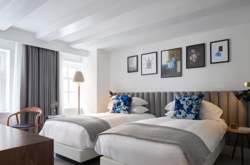 a hotel room with two beds and a table at Kimpton De Witt Amsterdam by IHG in Amsterdam
