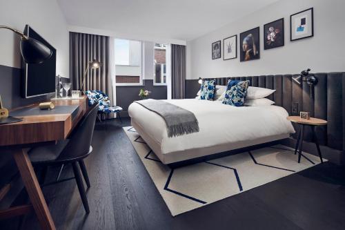 a hotel room with a bed and a desk and a computer at Kimpton De Witt Amsterdam by IHG in Amsterdam
