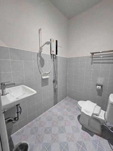 a bathroom with a shower and a toilet and a sink at Triple D Hotel in Betong