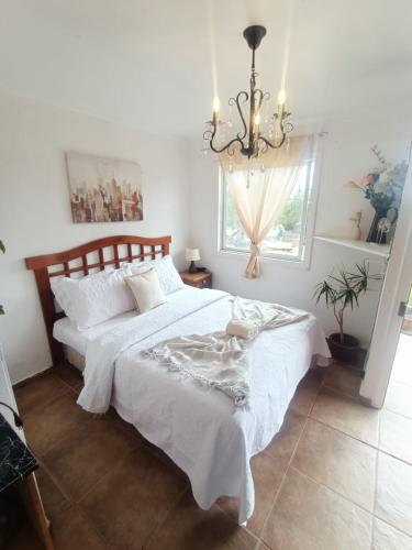 a bedroom with two beds and a chandelier at Cabañas Toto Península Beach in Totoralillo
