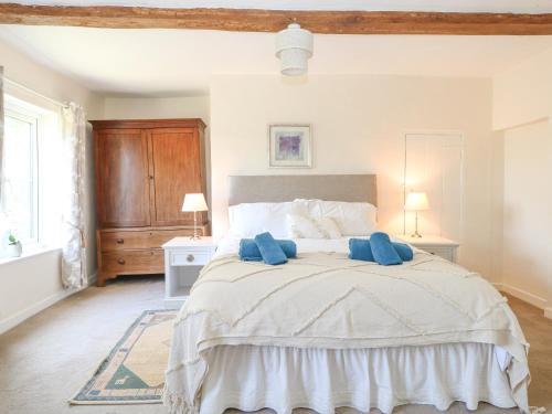 a bedroom with a large bed with two blue towels on it at Lyons Green in Great Fransham