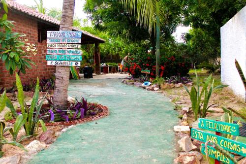 a street sign in front of a house with signs at Canoa Roots Hostel & Camping in Canoa Quebrada