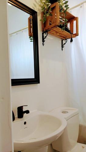 a bathroom with a toilet and a sink and a mirror at Cabañas Toto Península Beach in Totoralillo