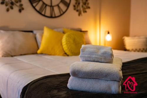 a pile of towels sitting on top of a bed at Pleasant View - An Irvie Home in Albuquerque