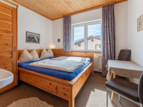 een slaapkamer met een bed, een raam en een wastafel bij Chalet Carina in Zell am See