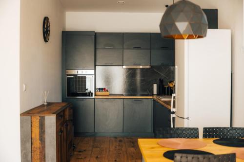 a kitchen with dark blue cabinets and a table at Apartmány Na Vŕšku in Kežmarok
