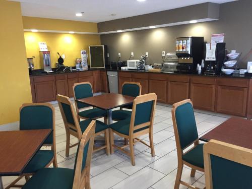 een restaurant met een tafel, stoelen en een toonbank bij Baymont by Wyndham Harvard in Harvard