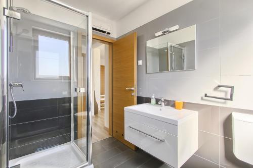 a bathroom with a white sink and a shower at Apartments Spagnolo in Ližnjan