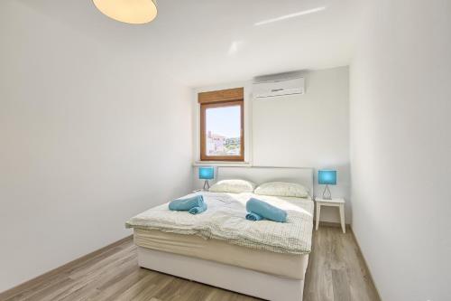 a bedroom with a bed with two blue pillows on it at Apartments Spagnolo in Ližnjan