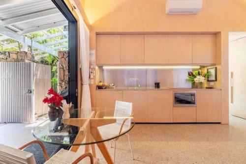 a kitchen with a glass table in a room at Buhwi Bira Byron Bay - Studio in Byron Bay