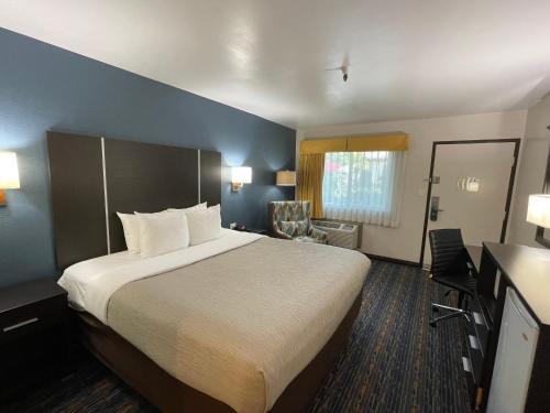 a hotel room with a large bed and a desk at Quality Inn Ontario Airport Convention Center in Ontario