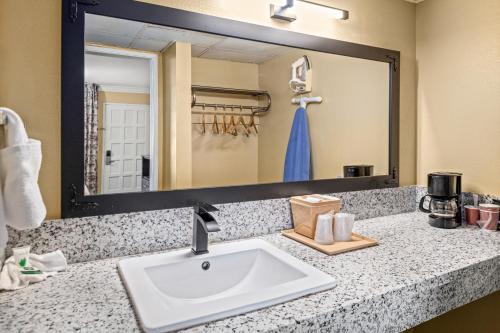 Cuenta con una encimera con lavabo y un espejo grande. en Vagabond Inn Costa Mesa, en Costa Mesa