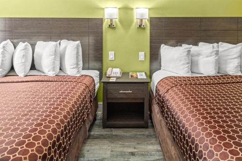 a hotel room with two beds and a phone at Vagabond Inn Costa Mesa in Costa Mesa
