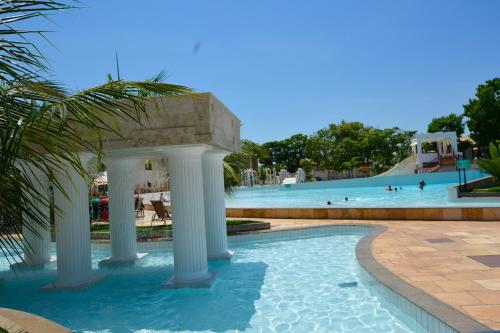 a swimming pool with a water park in the background at Apartamento Via Caldas L'Acqua II in Caldas Novas