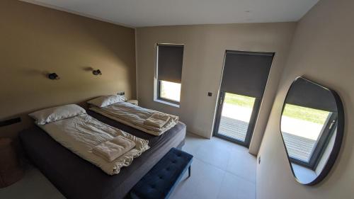 a small bedroom with two beds and a mirror at Black Beach Apartment - Vík in Vík