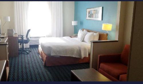 a hotel room with a bed and a chair at AmericInn by Wyndham Moline Airport/Quad Cities in Moline