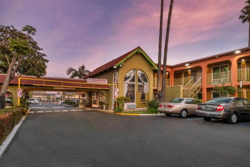 a parking lot with cars parked in front of a building at Vagabond Inn Costa Mesa in Costa Mesa