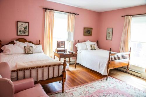 2 Betten in einem Schlafzimmer mit rosa Wänden in der Unterkunft Historic 1850s Home at the Base of Jump Mountain Near Lexington in Goshen
