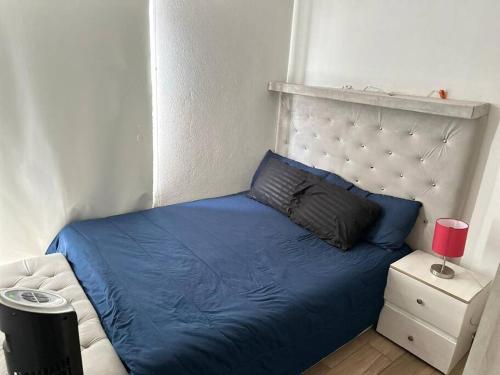 1 dormitorio con cama azul y cabecero en Departamento Céntrico en CDMX, en Ciudad de México