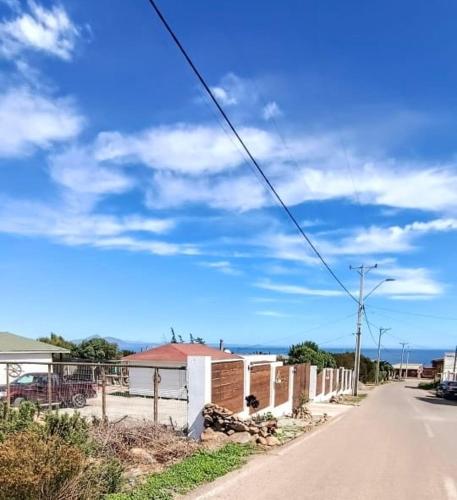 an empty street with a blue sky and clouds at Cabañas Toto Península Beach in Totoralillo