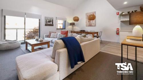 a living room with a couch and a table at Snowbound Chalet 5 in Thredbo