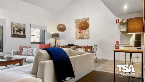 a living room with a couch and a table at Snowbound Chalet 5 in Thredbo