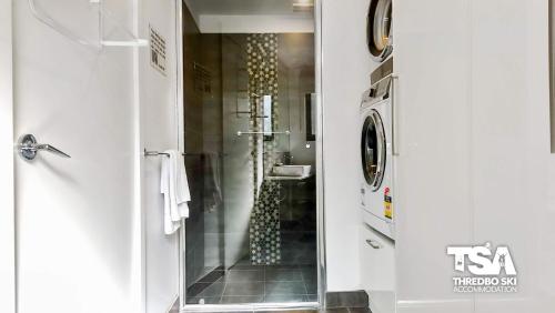 a bathroom with a sink and a shower with a mirror at Snowbound Chalet 5 in Thredbo