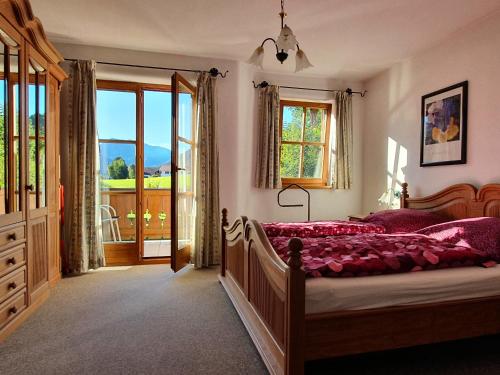 - une chambre avec un lit avec des draps roses et une fenêtre dans l'établissement Ferienwohnung Wiesenleiten, à Ruhpolding