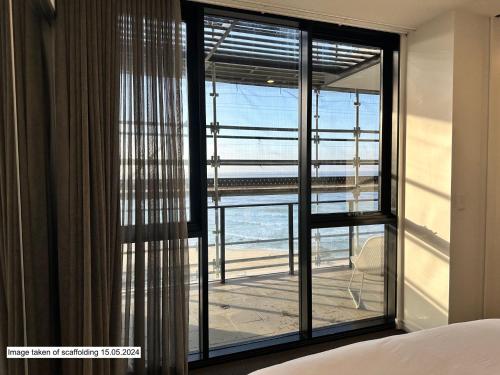 a bedroom with a window with a view of the ocean at The Aire in Newcastle