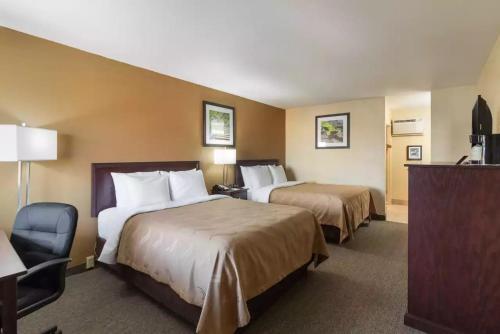 um quarto de hotel com duas camas e uma cadeira em Great Valley Inn em Union Gap
