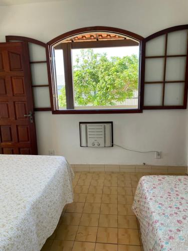una camera con due letti e una finestra di Casa estilo colonial, tranquila e perto de tudo! a São Pedro da Aldeia