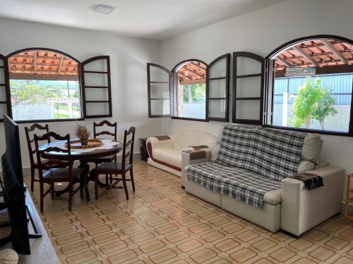 un soggiorno con divano e tavolo di Casa estilo colonial, tranquila e perto de tudo! a São Pedro da Aldeia