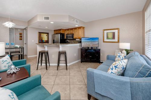 a living room with two blue couches and a kitchen at 406 Dockside in Clearwater Beach