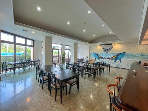 a dining room with tables and chairs and a mural at Kerama Blue Resort in Zamami