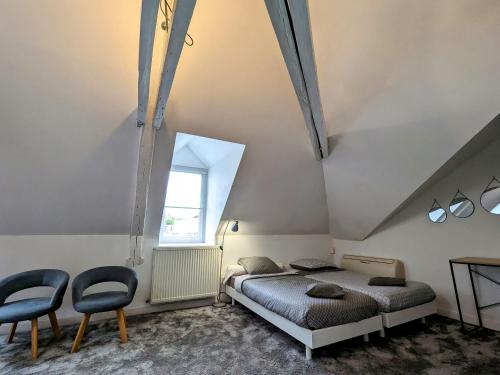1 dormitorio con 2 camas y 2 sillas en Guestroom Châteauroux, 1 pièce, 4 personnes - FR-1-591-388, en Châteauroux
