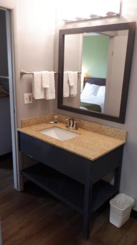 W łazience znajduje się umywalka i lustro. w obiekcie Great Valley Inn w mieście Union Gap