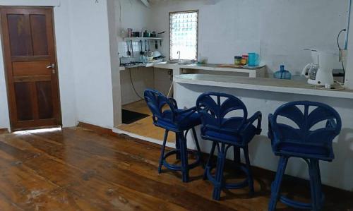 três bancos azuis em frente a um balcão de cozinha em Cabaña Adicora em Adícora