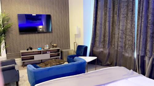 a room with a bed and a tv on a wall at The Lux Ville, Stunning 6 Bedroom Home in London in Plumstead