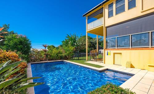 a swimming pool in front of a house at Buena Vista - Luxe 4 bedroom house, Views, Beach in Yeppoon