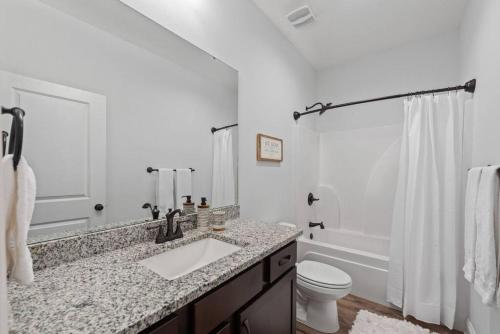 a white bathroom with a sink and a toilet at Sound Haven Coastal Escape in Navarre