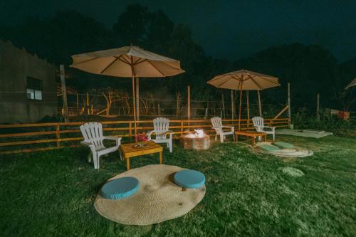 a group of chairs and tables with umbrellas at Casa vacacional Olon in Olón